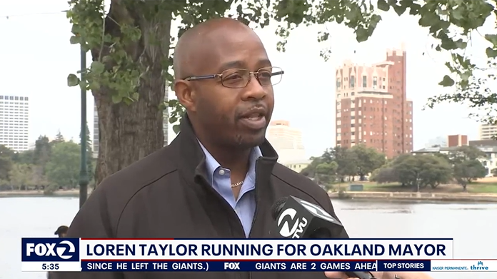 Loren Taylor in a black jacket being interviewed by Fox2; Chryon says "Loren Taylor Running for Oakland Mayor"