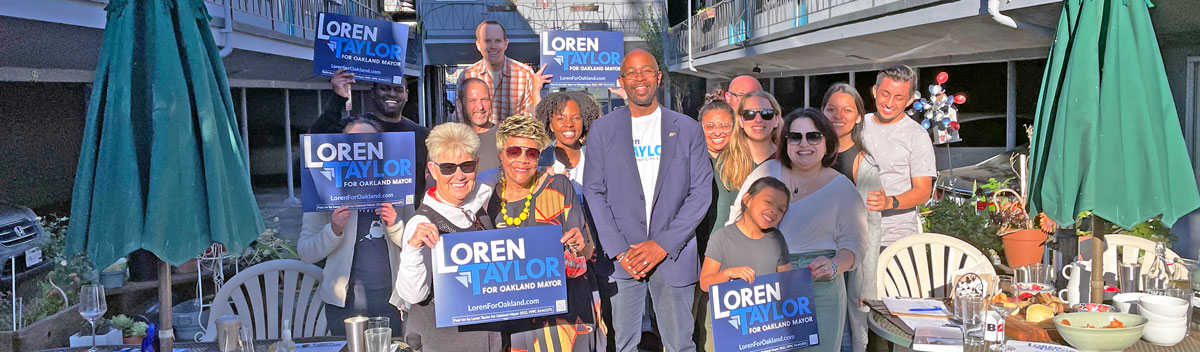 Photo of a group of people including Loren Taylor outside at a House Party; sunny day; people are holding signs that say "Loren Taylor for Mayor"