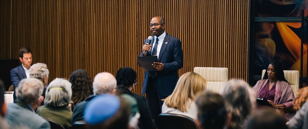 Loren Taylor with a microphone speaking to a crowd